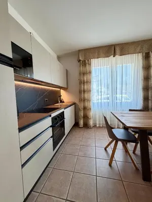a kitchen with a table and a dining room at Villa Serena - appartamento a Fiera di Primiero in Tonadico