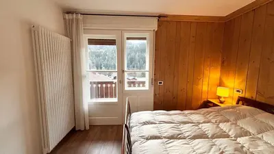 a bedroom with a bed and a window at Comodo appartamento a San Vito di Cadore in San Vito di Cadore