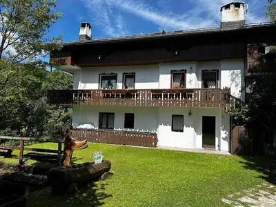 a house with a statue in front of it at Chalet Sofia in San Vito di Cadore