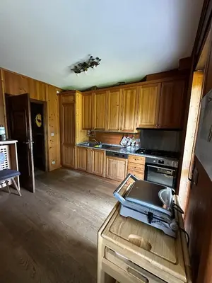 a kitchen with wooden cabinets and a drone on a table at Chalet Sofia in San Vito di Cadore