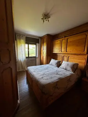 a bedroom with a large bed with a wooden headboard at Chalet Sofia in San Vito di Cadore