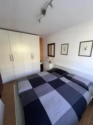 a bedroom with a black and white bed and cabinets at Chez Mati by Sunhome Fiemme in Cavalese