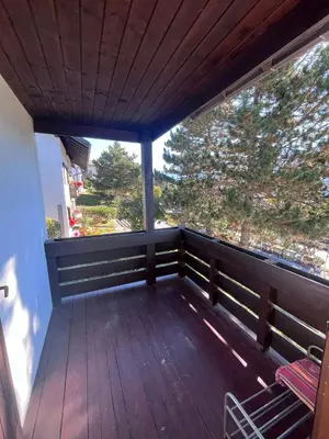 a balcony with a wooden deck with chairs on it at Chez Mati by Sunhome Fiemme in Cavalese