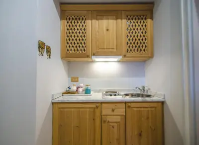 a small kitchen with wooden cabinets and a sink at Monolocale romantico tra le vette di Cortina in Cortina dʼAmpezzo