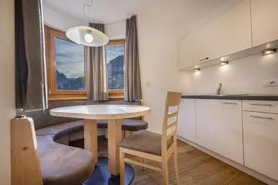 a small kitchen with a table and a window at Apartments Monica in Santa Cristina in Val Gardena