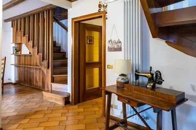 a room with a table and a hallway with stairs at Appartamento Al Cirmolo - 4 Camere in Pieno Centro di Fiera di Primiero in Fiera di Primiero