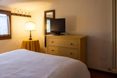 a bedroom with a bed and a television on a dresser at Appartamento Al Cirmolo - 4 Camere in Pieno Centro di Fiera di Primiero in Fiera di Primiero