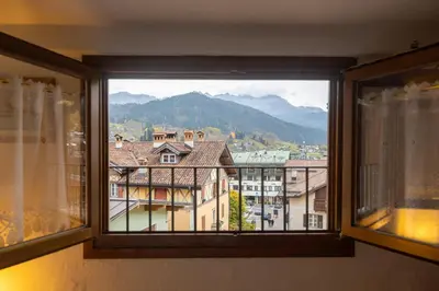 a window with a view of a building at Appartamento Al Cirmolo - 4 Camere in Pieno Centro di Fiera di Primiero in Fiera di Primiero