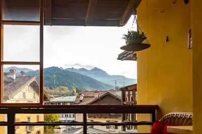 a window with a view of a city and mountains at Appartamento Al Cirmolo - 4 Camere in Pieno Centro di Fiera di Primiero in Fiera di Primiero