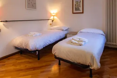 two twin beds in a room with at Appartamento Al Cirmolo - 4 Camere in Pieno Centro di Fiera di Primiero in Fiera di Primiero