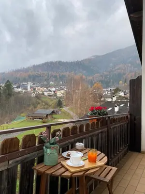 a table on a balcony with a view of a mountain at Sole & Luna Dolomiti House in Voltago