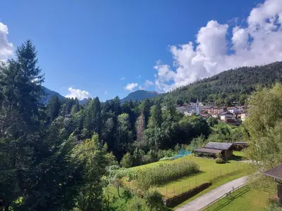 a view of a valley with a village in the distance at Sole & Luna Dolomiti House in Voltago