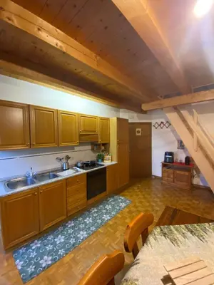 a kitchen with wooden cabinets and a sink at Sole & Luna Dolomiti House in Voltago