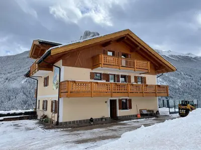 a house with a balcony on top of it in the snow at Casa Davarda - Appartamento Lusia in Vigo di Fassa