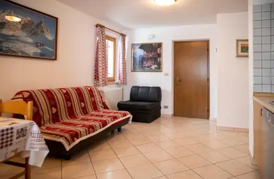 a living room with a couch and a chair at Casa Davarda - Appartamento Lusia in Vigo di Fassa