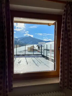 a window with a view of a snowy mountain at Casa Davarda - Appartamento Lusia in Vigo di Fassa
