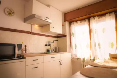 a kitchen with white cabinets and a microwave and a window at Casa vacanze Danoi Dolomiti in Canale dʼAgordo