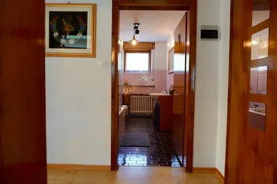 a hallway with a door open to a room with a kitchen at Casa vacanze Danoi Dolomiti in Canale dʼAgordo