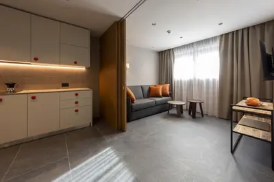 a kitchen and living room with a couch and a table at Dolomiten Apartments in Tesero