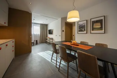 a kitchen and dining room with a table and chairs at Dolomiten Apartments in Tesero