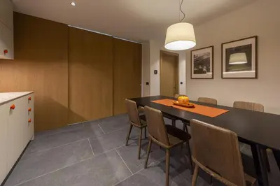 a kitchen and dining room with a table and chairs at Dolomiten Apartments in Tesero