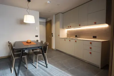 a kitchen with a table and chairs and a counter at Dolomiten Apartments in Tesero
