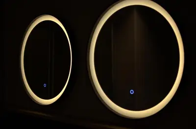 a pair of round mirrors on a black background at Dolomiten Apartments in Tesero