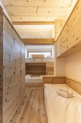a room with two bunk beds and a window at Casa Poligrafica 1 in Cortina dʼAmpezzo