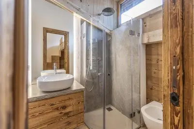 a bathroom with a sink and a glass shower at Casa Poligrafica 1 in Cortina dʼAmpezzo