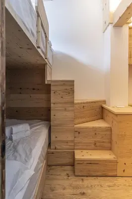 a bedroom with wooden walls and bunk beds at Casa Poligrafica 1 in Cortina dʼAmpezzo