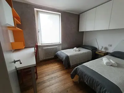 a small room with two beds and a window at Casa Evelina con Parcheggio esterno e Garage gratis, appartamento con idromassaggio per due in Sanzeno