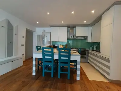a kitchen with blue chairs and a kitchen island at Casa Evelina con Parcheggio esterno e Garage gratis, appartamento con idromassaggio per due in Sanzeno