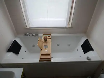a bath tub in a bathroom with a window at Casa Evelina con Parcheggio esterno e Garage gratis, appartamento con idromassaggio per due in Sanzeno
