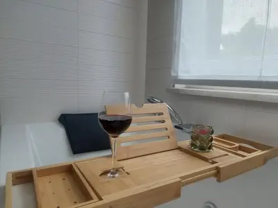 a glass of wine sitting on a wooden tray at Casa Evelina con Parcheggio esterno e Garage gratis, appartamento con idromassaggio per due in Sanzeno