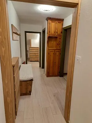 a hallway with a room with a bed and wooden floors at Casa Amabile in Cortina dʼAmpezzo