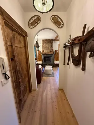 a hallway with a door and a room with a fireplace at SciaLet in Campitello di Fassa
