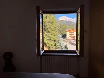 a window in a bedroom with a view of a mountain at SciaLet in Campitello di Fassa