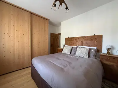 a bedroom with a large bed and wooden cabinets at SciaLet in Campitello di Fassa