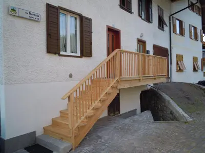 a wooden staircase next to a building with a window at Luigi Apartment in Varena
