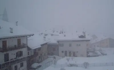 a city covered in snow with buildings and roofs at Luigi Apartment in Varena