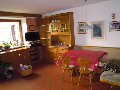 a kitchen with a table and chairs and a television at Luigi Apartment in Varena