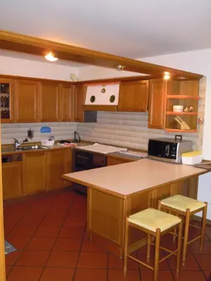 a kitchen with wooden cabinets and a counter top at Luigi Apartment in Varena