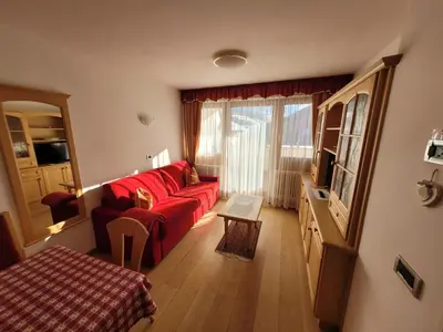 a living room with a red couch and a window at Chalet Milandora in La Villa