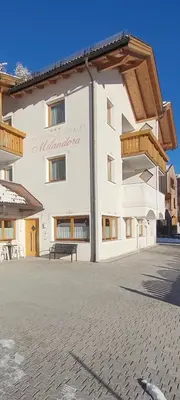 a large white building with a bench in front of it at Chalet Milandora in La Villa