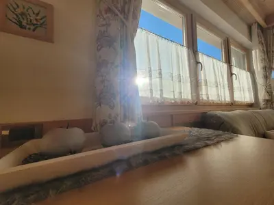 a living room with a table and a window at Chalet Milandora in La Villa