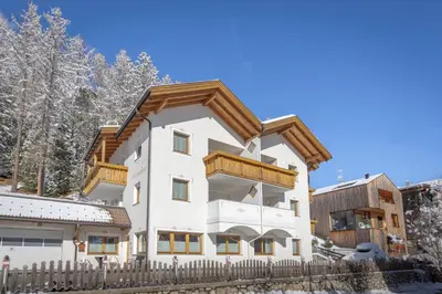 a house in the snow with a wooden fence at Chalet Milandora in La Villa