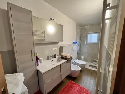 a bathroom with a white sink and a toilet at Casa Angela in Cavalese