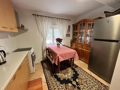 a kitchen with a table and a refrigerator at Casa Angela in Cavalese