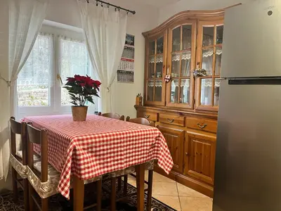 a kitchen with a table with a red and white checkered table cloth at Casa Angela in Cavalese