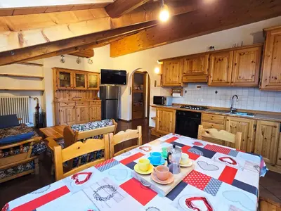 a living room with a table and chairs and a window at Attico Lagorai - Alpine Stay Apartments in Ziano di Fiemme
